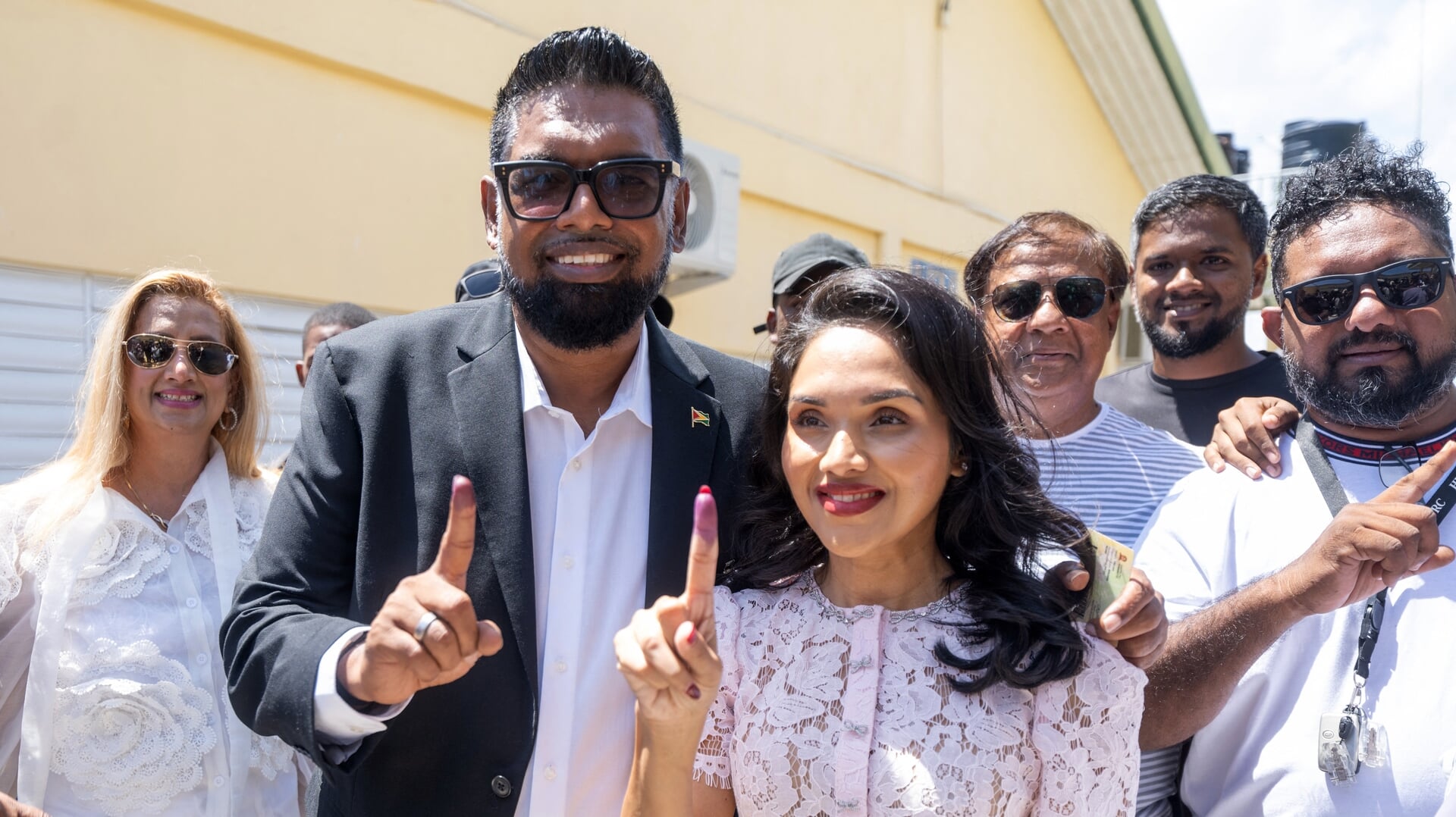 Mohamed Irfaan Ali, de president van Guyana, met zijn echtgenote bij een stembureau.