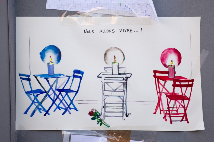 ‘Nous allons vivre...!’, ‘we leven...’ hangt er aan het raam van restaurant Le Petit Cambodge in Parijs.