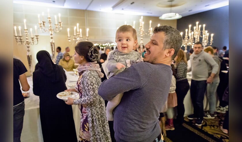 Vluchtelingen maken zich gereed om aan tafel te gaan in het Amsterdamse Hilton Hotel voor het kerstdiner van Stichting Havenstraat. Deze stichting organiseert, met steun van bedrijven uit de hoofdstad en omstreken, diners met vluchtelingen, om hun afleiding te bezorgen en Amsterdammers met hen te laten kennismaken. < (anp / Bart Maat)