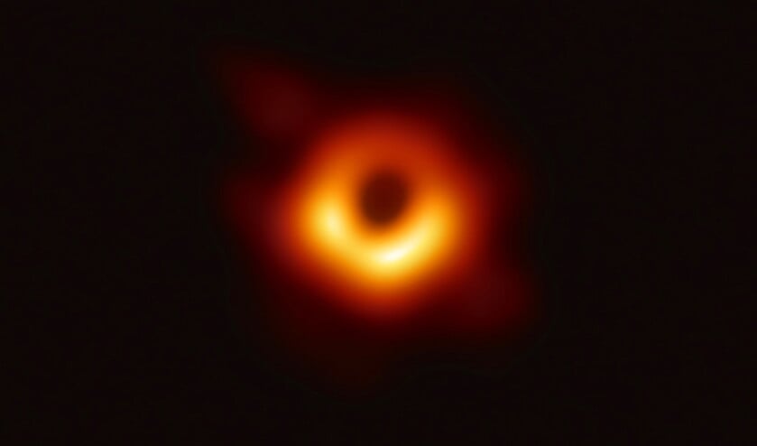 Het zwarte gat in het centrum van sterrenstelsel M87. De oranjegele ring is licht dat afkomstig is van materie rond het zwarte gat. Deze draait met de klok mee om het zwarte gat: aan de bovenkant beweegt de materie van ons af, aan de onderkant komt ze naar ons toe. Het dopplereffect zorgt ervoor dat de straling die naar ons toe komt helderder lijkt.