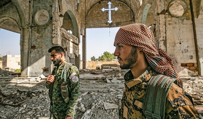 Leden van de Bewakers van Khabour, een Assyrische militie binnen de SDF, lopen in de ruïne van de Assryische kerk van de maagd Maria in het dorp Tal Nasri, ten zuiden van Tel Tamr. De kerk werd door ISIS al verwoest. Nu wordt het dorp opnieuw bedreigd, door Turkije en aan Turkije verbonden milities. (afp / Delil Souleiman)