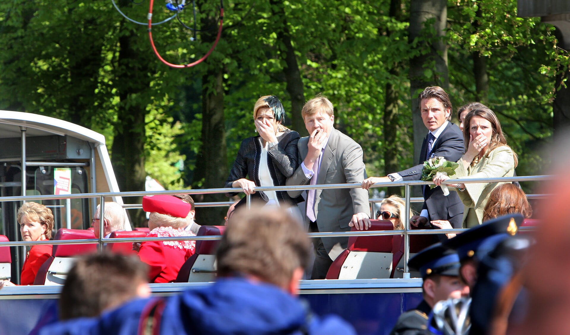 Koninginnedag 2009: prinses Máxima, prins Willem-Alexander, prins Maurits en prinses Annette kijken geschrokken als er in Apeldoorn een auto vlak langs hun bus op het publiek inrijdt.