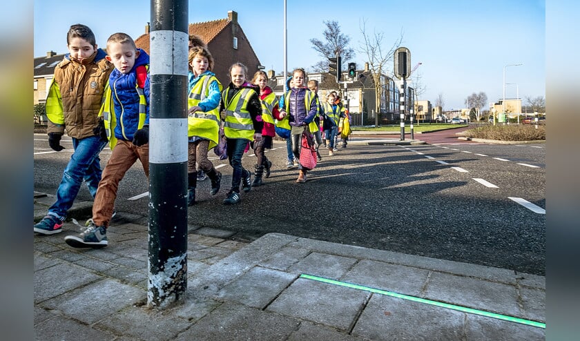 De groene lichtlijn in de stoep moet verstokte telefoongebruikers helpen om zich veilig te gedragen in het verkeer. (Raymond Rutting)