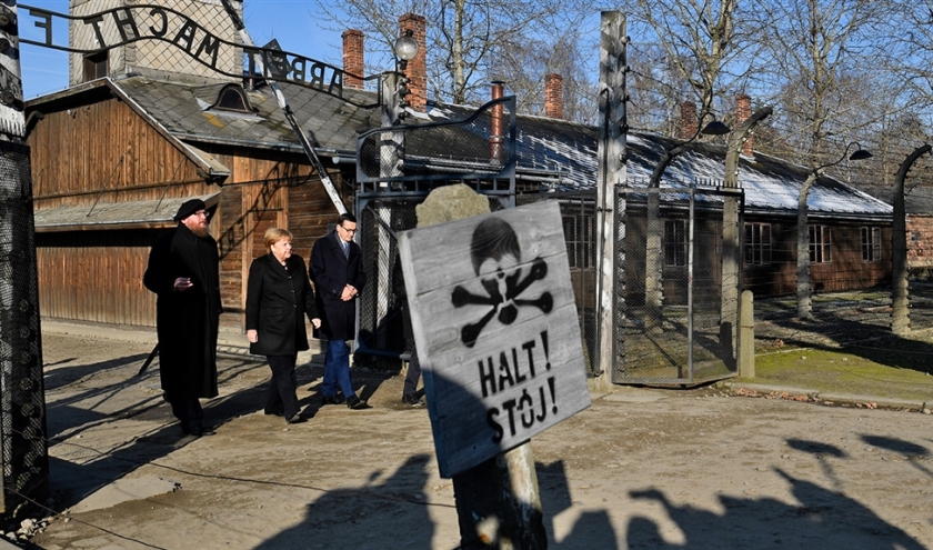De Poolse president Mateusz Morawiecki en de directeur van het Staatsmuseum en de Stichting Auschwitz-Birkenau Piotr Cywinski ontvingen de Duitse bonds-kanselier Angela Merkel vrijdag in het concentratiekamp. Merkel zei zich te schamen voor de gruweldaden die de nazi’s daar tijdens de Tweede Wereldoorlog hebben begaan (afp / John Macdougall)