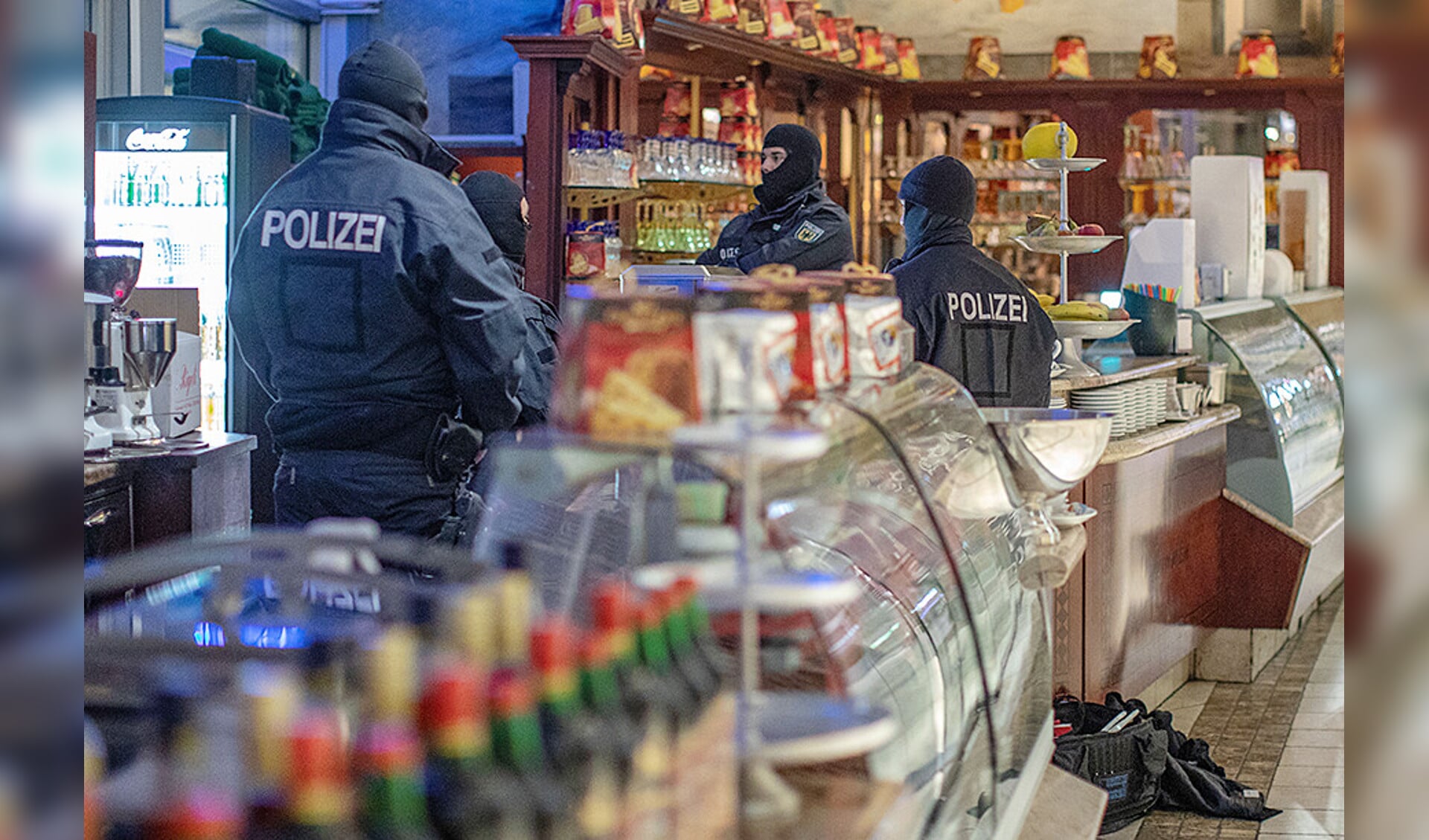 Politieagenten vallen een ijssalon binnen tijdens de internationale actie tegen de Italiaanse maffiaorganisatie ‘Ndrangheta, afgelopen woensdagochtend.
