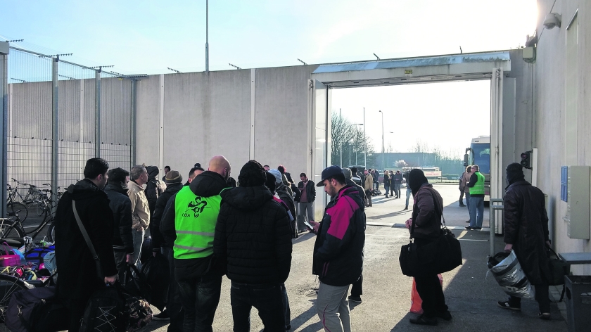 Vluchtelingen in de Alphense opvang wachten tot de bus arriveert die hen naar de opvanglocatie in Ter Apel zal brengen. (nd)