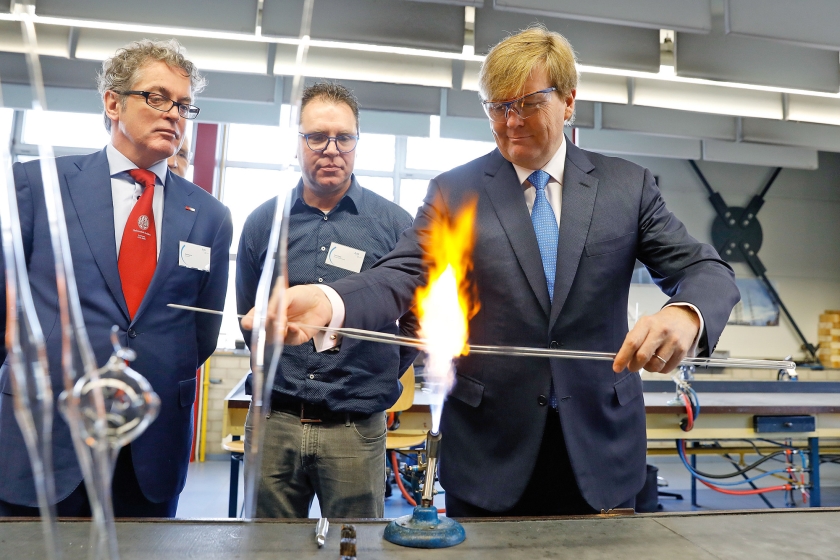 Koning Willem-Alexander (r.) steekt bij de opening van de nieuwe vleugel van de Leidse instrumentmakers School ook zelf de handen uit de mouwen. (Dick den Braber en anp / Bas Czerwinski)
