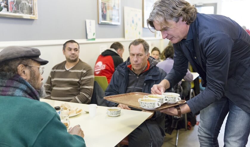 Dominee Gert Hutten, directeur van Tot Heil des Volks, serveert soep. ‘Iedereen is welkom, ook als je elders niet binnenkomt.’ (Klaas Driebergen)