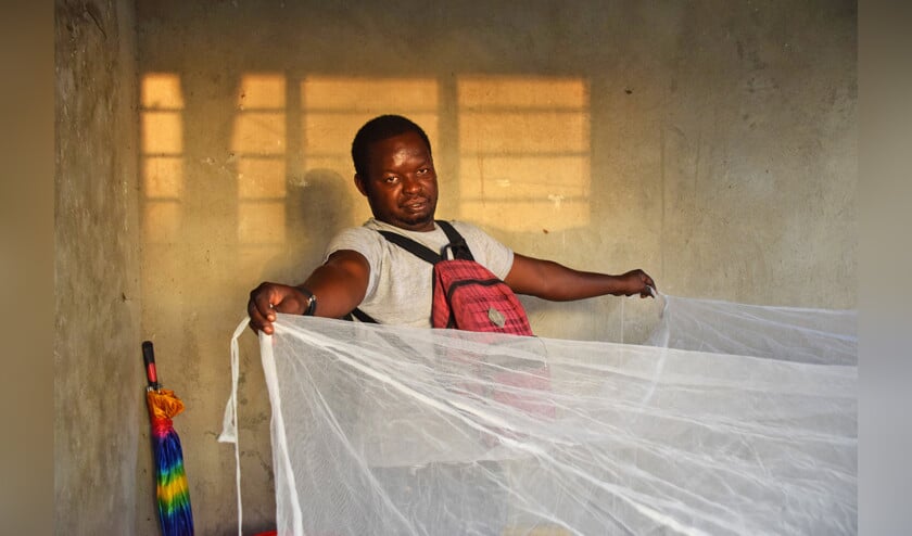Dario in zijn huis met het malarianet dat hij gratis gekregen heeft. ‘Het net vergeet ik vaak op te hangen.’  (Marjolein Koster)