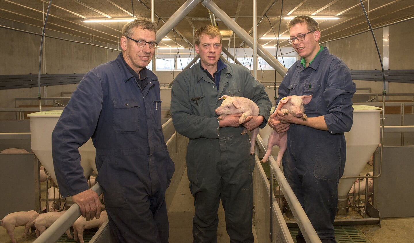 Henk Dekker en zijn zoons Arjan en Gerben in de nieuwe varkensstal.