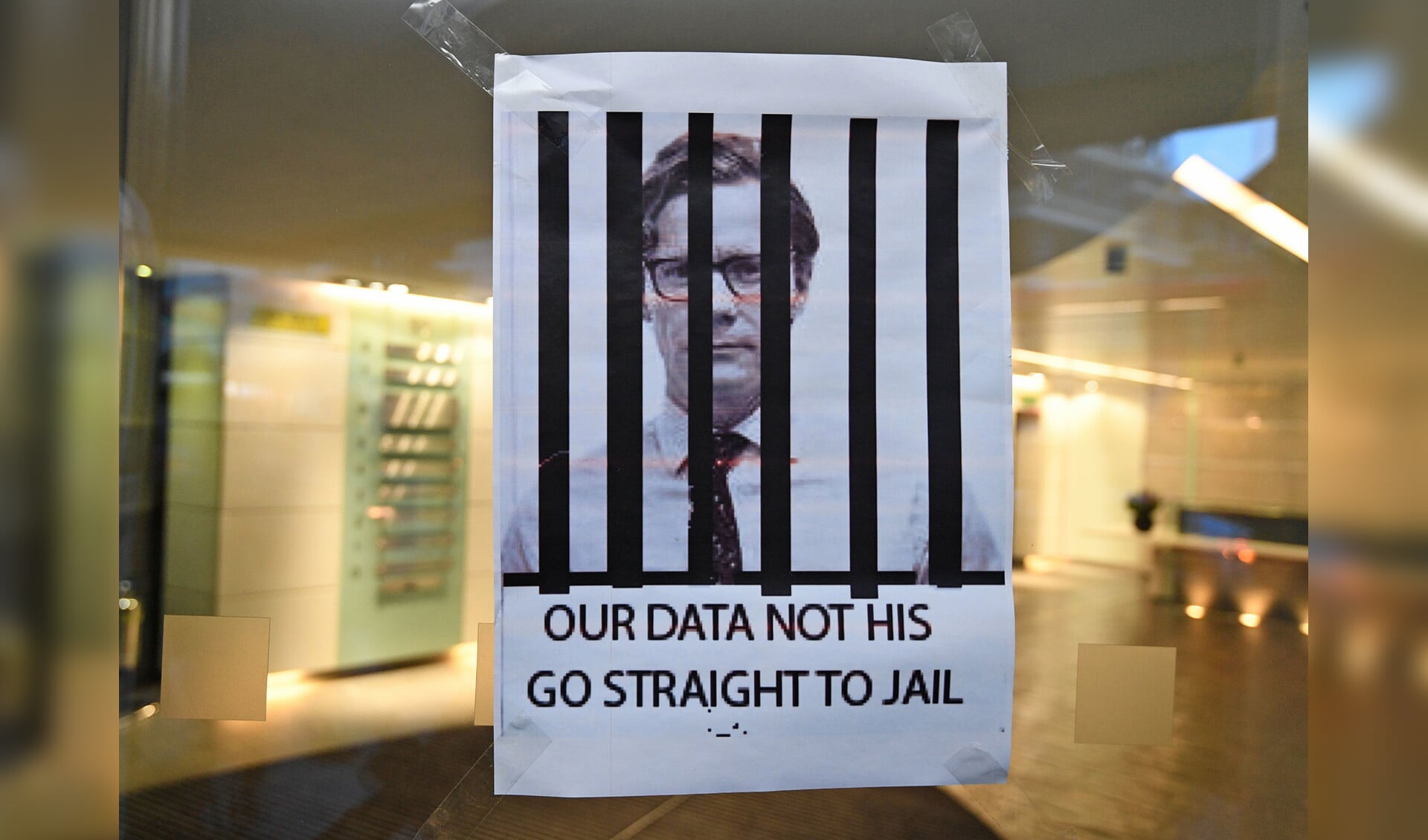 Een protestposter met de afbeelding van Alexander Nix, topman van Cambridge Analytica, dat op grote schaal data vergaarde van Facebook.