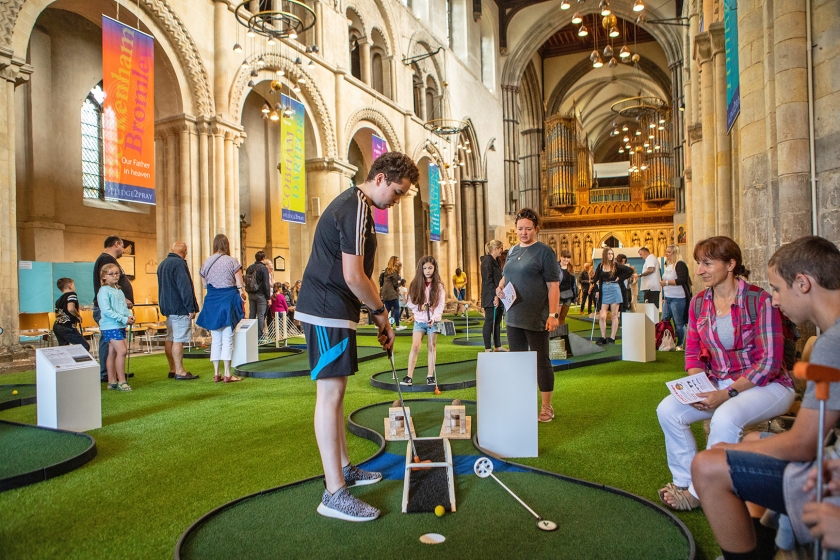 Bezoekers van de middeleeuwse kathedraal van Rochester leven zich uit op de minigolfbaan van negen holes, op de plek waar anders de congregratie zit. (Antonio Olmos)