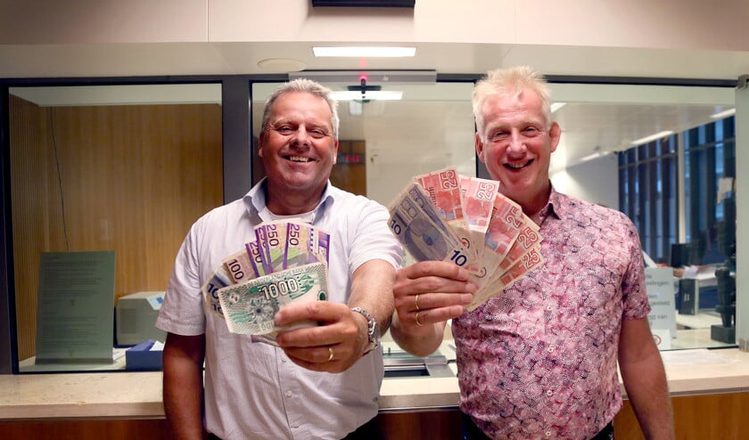 Rob Ruizendaal (links) en Frank van der Horst met biljetten die ingeleverd zijn bij het guldenloket van De Nederlandsche Bank. (dnb / Marieke Bijster)
