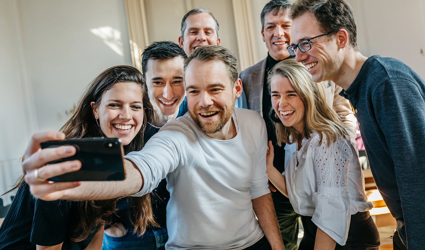Henrik Wienen (met telefoon) gelooft dat kerk-apps een middel kunnen zijn om een plaatselijke kerkgemeenschap hechter te maken.