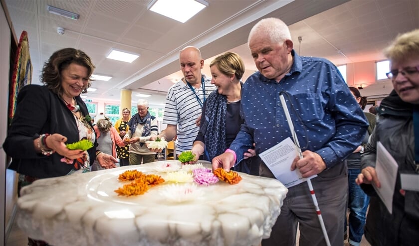 Om hun veelkleurigheid te vieren, leggen de bewoners van Bartiméus een bloem op het water van de doopvont. (Carel Schutte)
