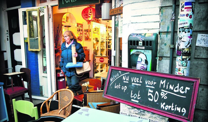 De eigenaar van een tweedehands winkel in Utrecht kondigt hoge korting aan. De armoede in Nederland stijgt licht, voornamelijk door het verlies aan koopkracht en het toenemend aantal werklozen in ons land. (anp / Ilvy Njiokiktjien)