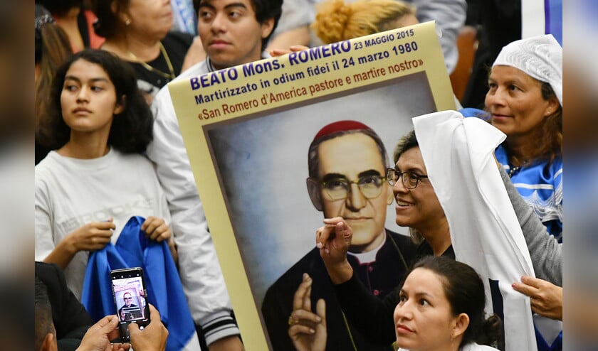 Pelgrims uit El Salvador houden een poster van bisschop Oscar Romero omhoog tijdens een bezoek aan het Vaticaan. (afp / Alberto Pizzoli)