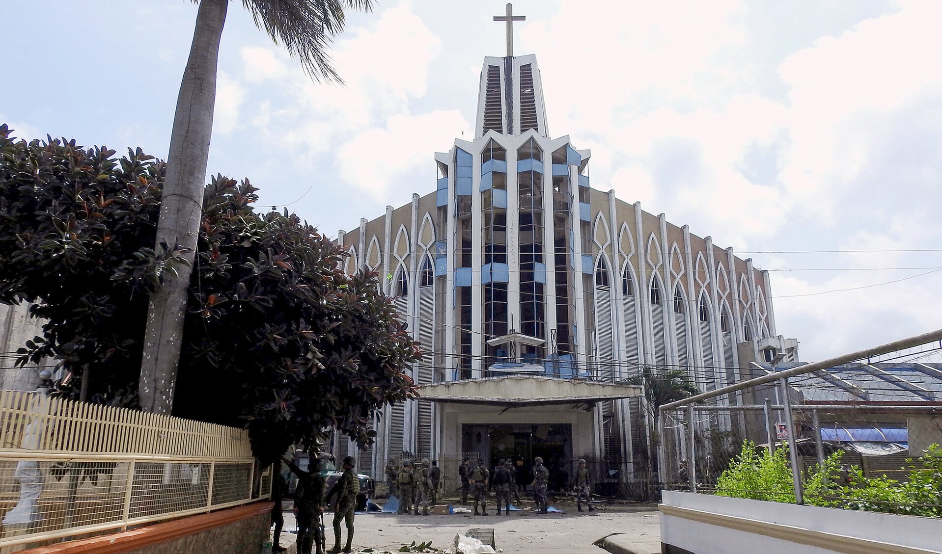 Politieagenten en soldaten bij de katholieke kathedraal in Jolo, waar zondag twee bommen ontploften. Bij de aanslag kwamen zeker twintig mensen om.