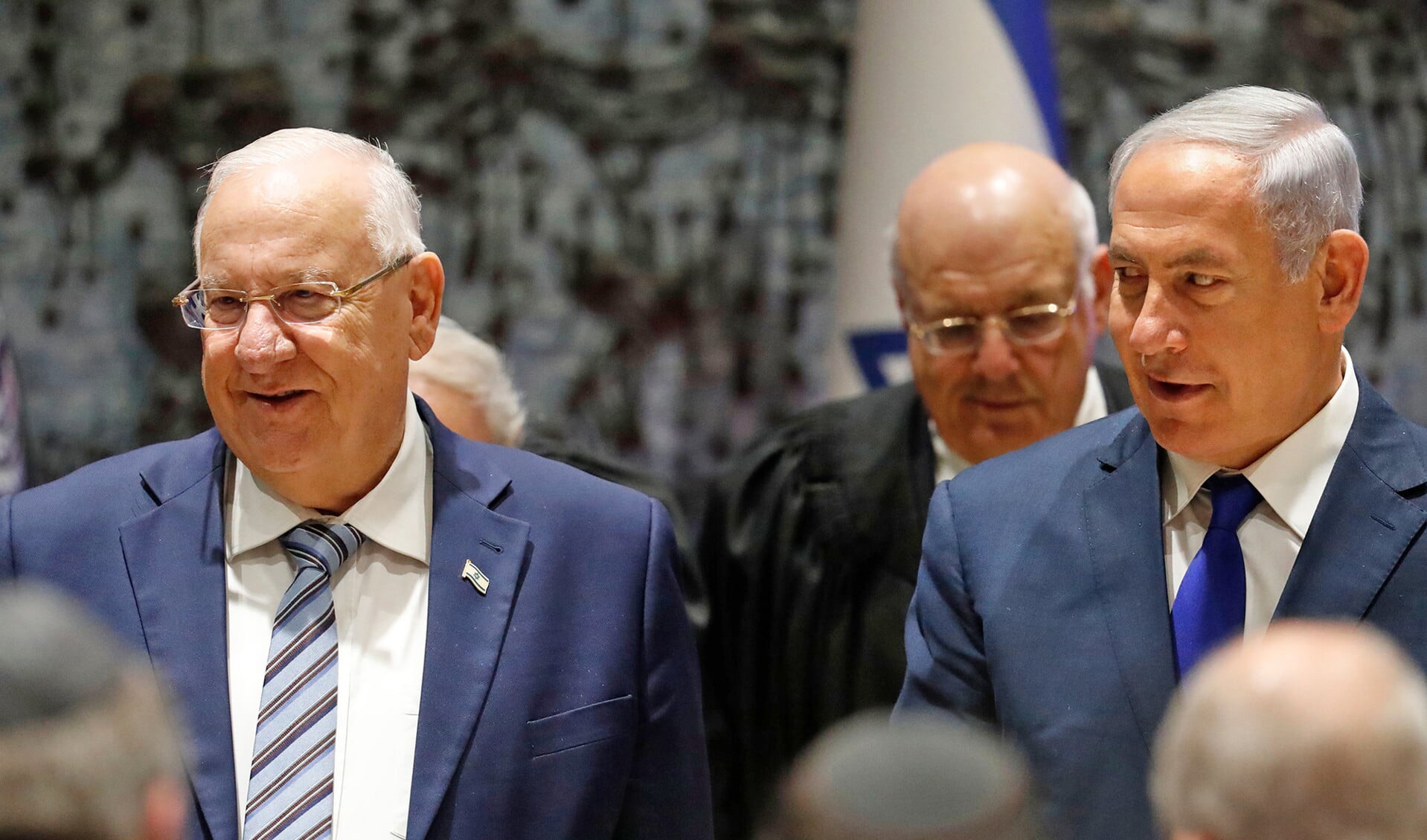 Premier Benjamin Netanyahu (rechts) hoort binnenkort van openbaar aanklager Avidhai Mandelblit of hij in staat van beschuldiging wordt gesteld wegens corruptie in drie afzonderlijke zaken. Reuven Rivlin staat links op de foto.