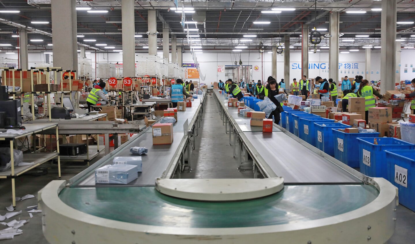 Het online winkelen en de zucht van consumenten om zo goedkoop mogelijk aan spullen te komen, daar kan een fabrikant in de eurozone bijna niet tegenop. Op de foto een distributiecentrum in China.