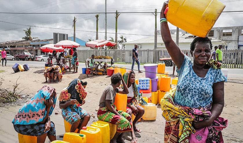 Vrouwen en meisjes met gele jerrycans wachten bij een van de nog werkende waterkranen in de stad Beira. (epa / Tiago Petinga)