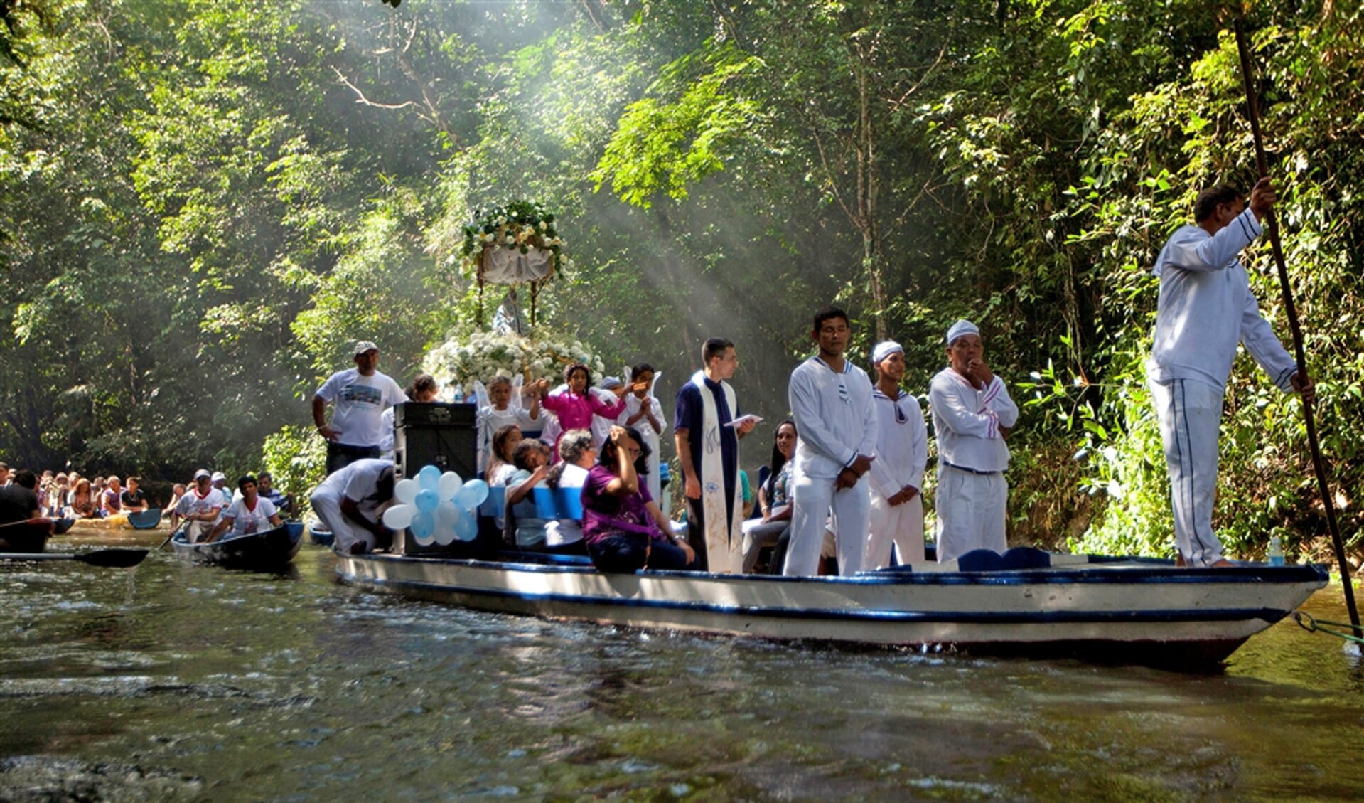 Rooms-katholieke pelgrims in een processie per boot ter gelegenheid van het jaarlijkse feest van Maria’s onbevlekte ontvangenis. Ze varen over de rivier de Caraparu in de Braziliaanse Amazone.