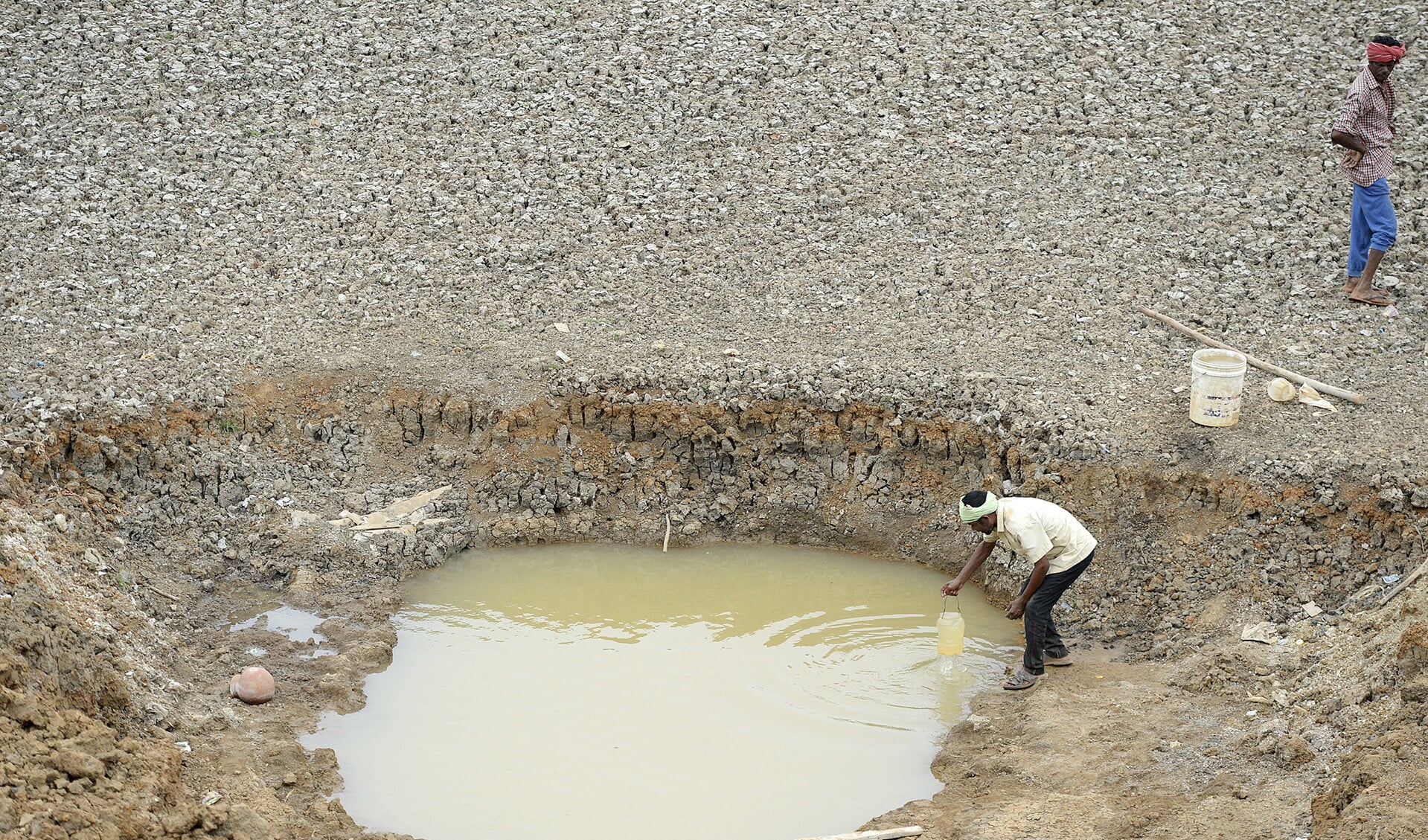 Een Indiase arbeider haalt water uit wat er nog over is van het Puzhal-stuwmeer aan de rand van Chennai. De waterstanden in de vier belangrijkste reservoirs in Chennai zijn gedaald tot een van de laagste niveaus in zeventig jaar.