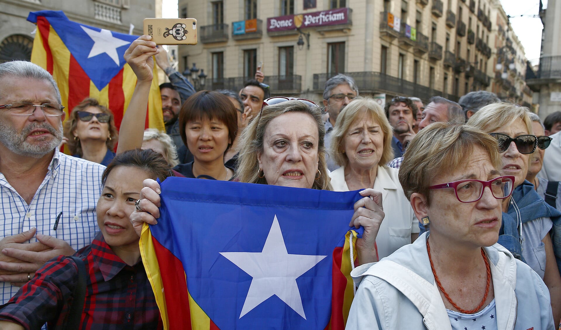 Bij een betoging in Barcelona tegen het opsluiten van leiders van de Catalaanse onafhankelijkheidsbeweging draagt een vrouw een estelada, een vlag die de onafhankelijkheid van Catalonië symboliseert.