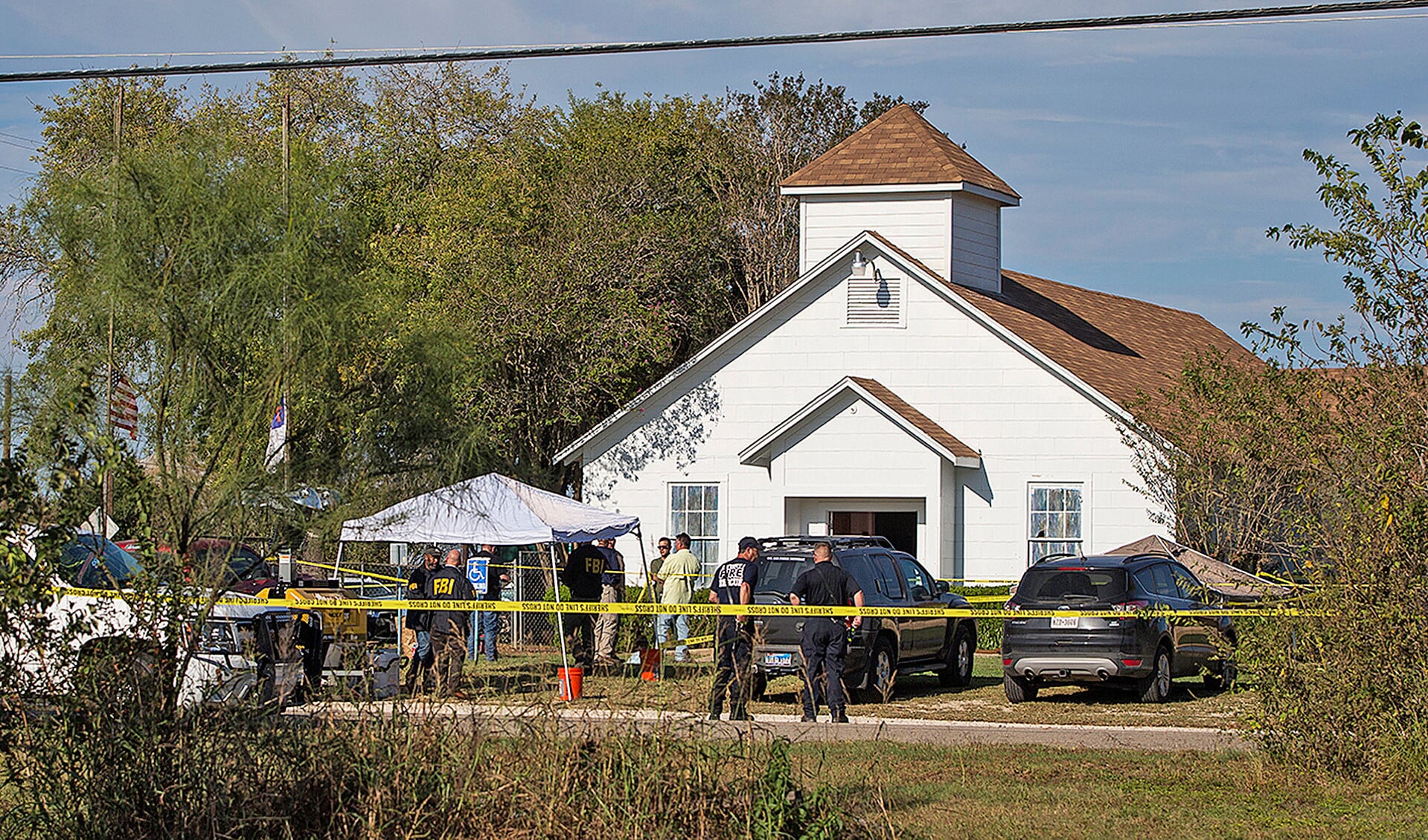 Politieambtenaren en leden van veiligheidsdiensten onderzoeken het terrein om de First Baptist Church in Sutherland Springs (Texas), waar zondag 26 mensen omkwamen bij een massale schietpartij.