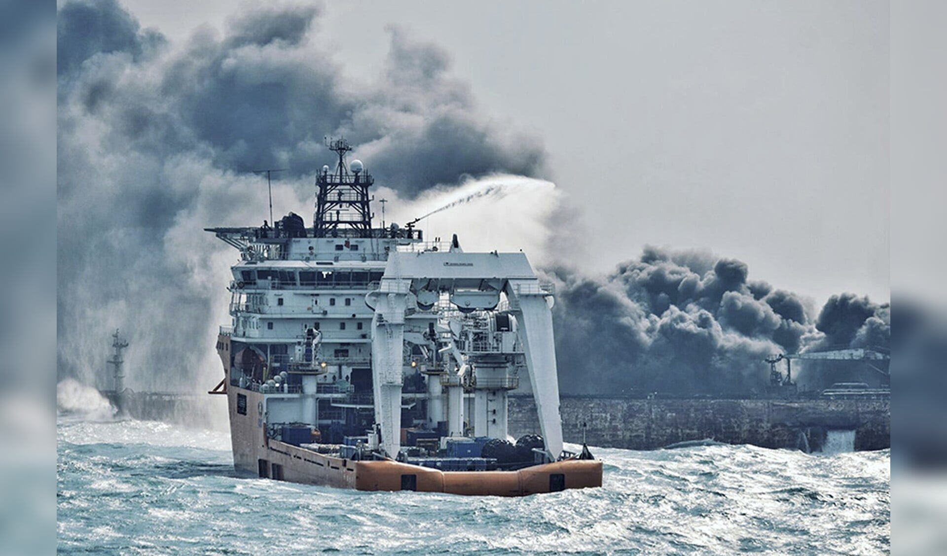 De bemanning van een blusboot probeert een einde te maken aan brand op de olietanker Sanchi in de Oost-Chinese Zee.
