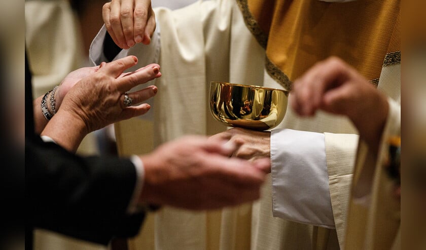 Paus Franciscus reikt de communie uit. Wat hem betreft moeten gescheiden mensen die hertrouwen in sommige gevallen weer ter communie kunnen gaan.  (ap / James Robinson)