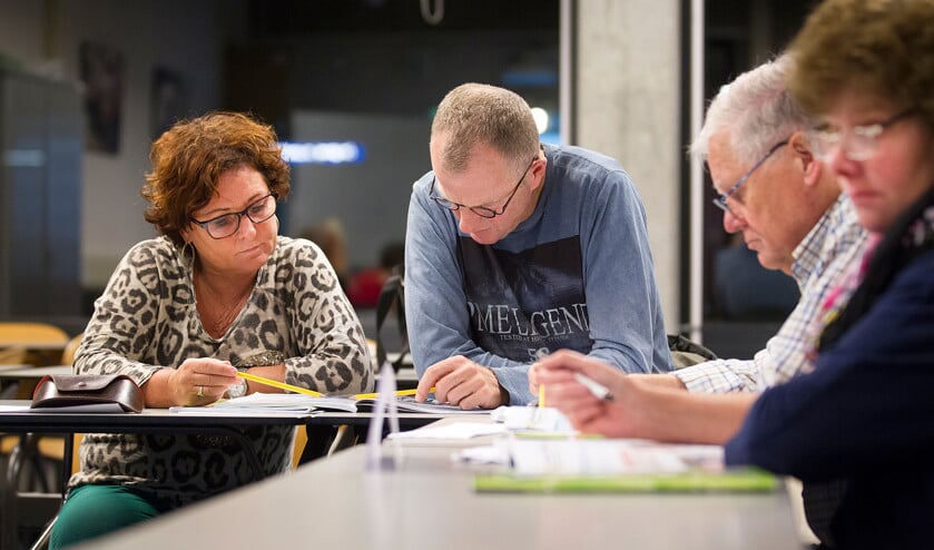 Concentratie tijdens de cursus Engels. Cristien en Hans de Jong, Frans Hanenberg en Clara Colijn (v.l.n.r.) beluisteren een geluidsfragment en proberen de bijbehorende vragen te beantwoorden. (Jeroen Jumelet)