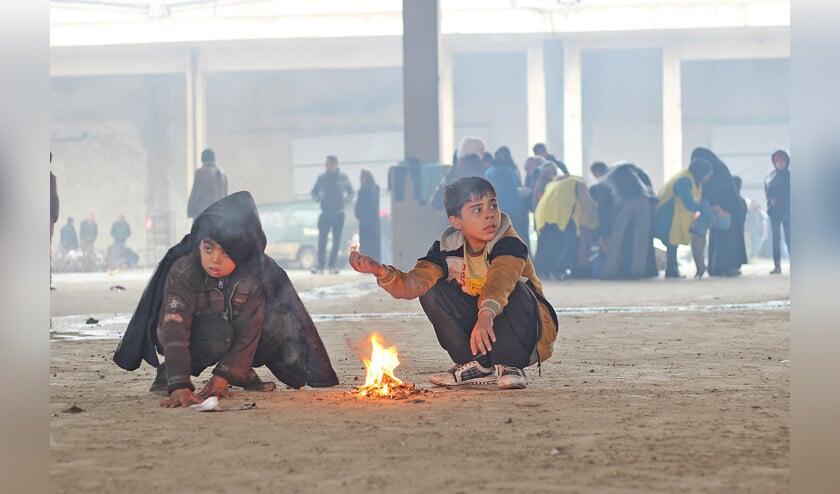 Begin december 2016 kleumen twee jongens bij een vuurtje in het opvangkamp Jibreen, ten oosten van Aleppo. (unicef / Khuder Al-Issa)