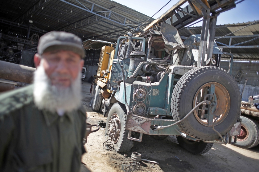 Een Palestijn neemt de schade op in zijn werkplaats in Gaza-Stad, nadat die donderdag door een bom getroffen was tijdens een Israëlische luchtaanval. Het voertuig op de foto is een truck die gebruikt wordt voor boorwerkzaamheden. (ap / Kahlil Hamra)