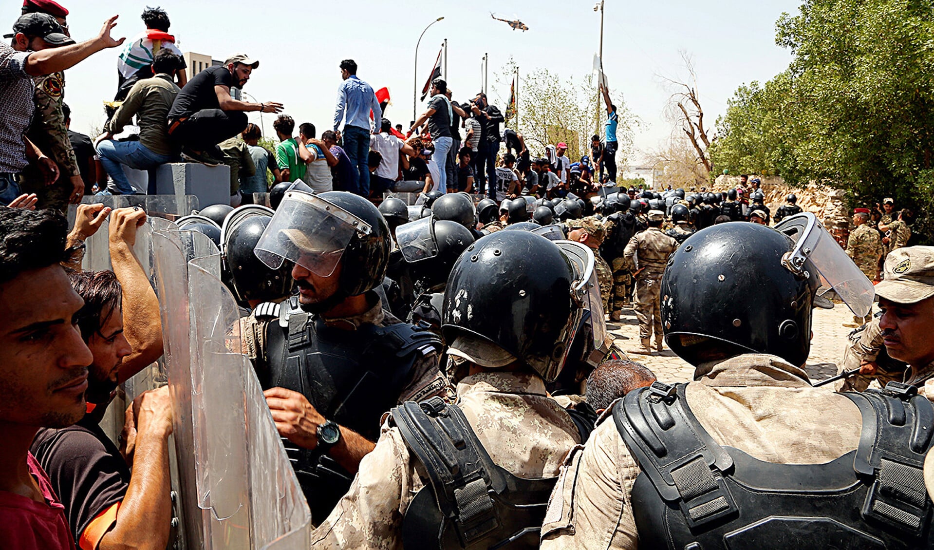 Iraakse agenten proberen demonstranten ervan te weerhouden het provinciale raadsgebouw in Basra te bestormen.