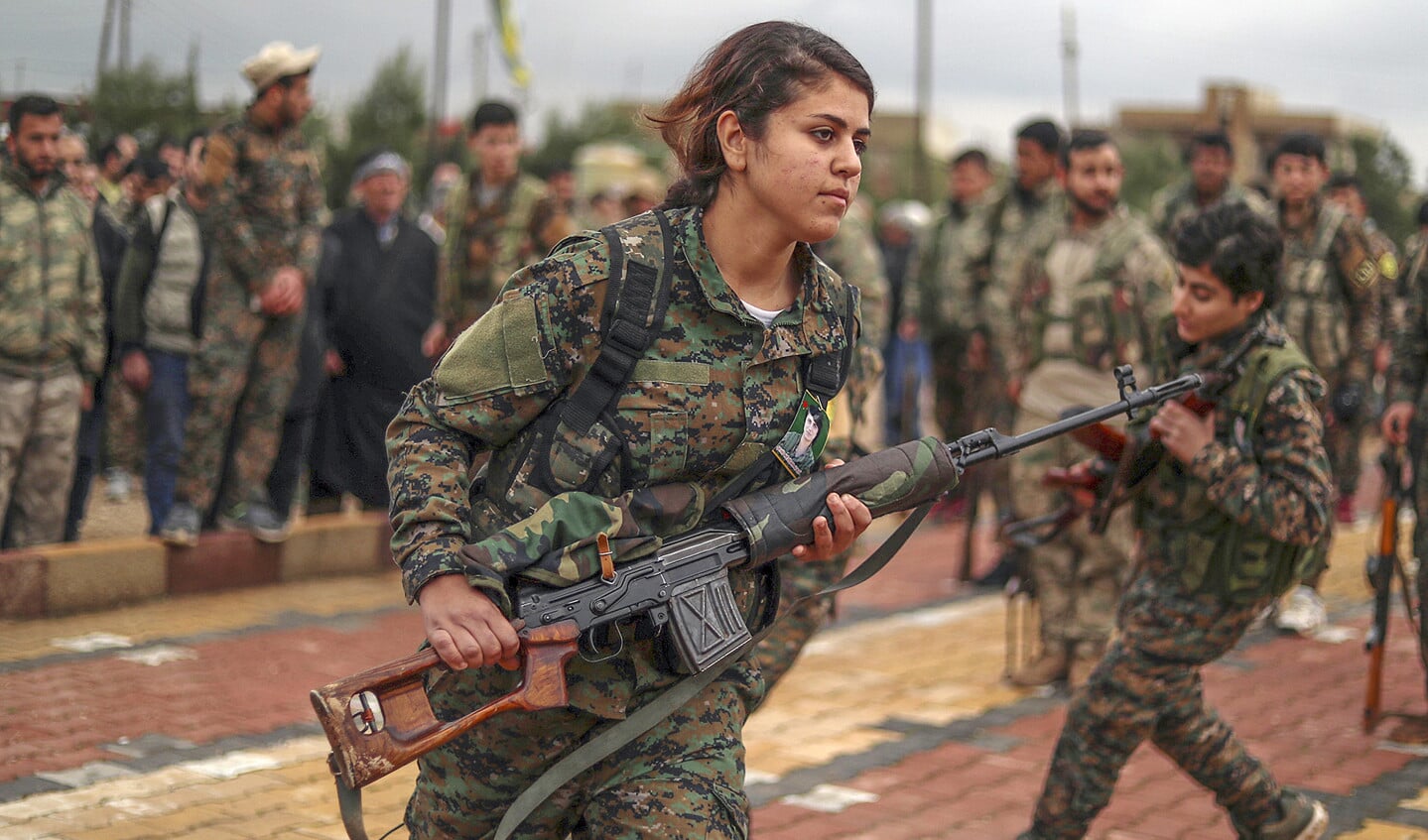 In de ‘laatste slag’ met ISIS vallen aan de kant van de Syrische Democratische Troepen nog steeds slachtoffers. Hier strijders van een Koerdische vrouweneenheid op de begrafenis van een collega, zaterdag in Qamishli.