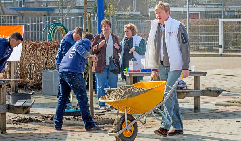 Politici en bestuurders zouden een dagdeel per week vrijwilligerswerk kunnen gaan doen in de samenleving. Hier helpen koning Willem-Alexander en koningin Máxima in een speeltuin, op de jaarlijkse klusdag van het Oranjefonds. (ap / Patrick van Katwijk)