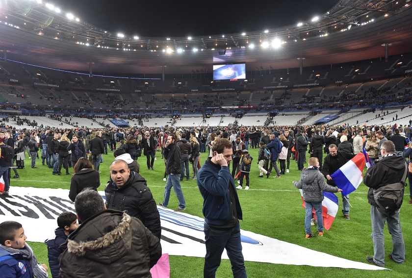 Toeschouwers stromen het veld op na het bomalarm tijdens de voetbalwedstrijd Frankrijk-Duitsland vrijdagavond. (ap / Uwe Anspach)