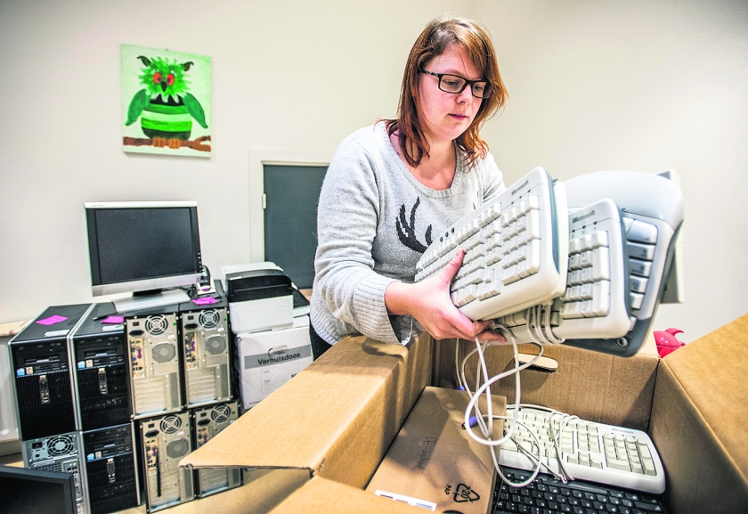 Hilde Lorier van Stichting Leergeld in Utrecht pakt een doos met toetsenborden uit voor haar cliënten. (Raymond Rutting)
