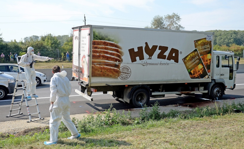 Het witte vrachtwagentje met het opschrift Hyza wordt onderzocht. In het vrachtruim werden 71 lijken van vluchtelingen aangetroffen. (epa / Roland Schlager)