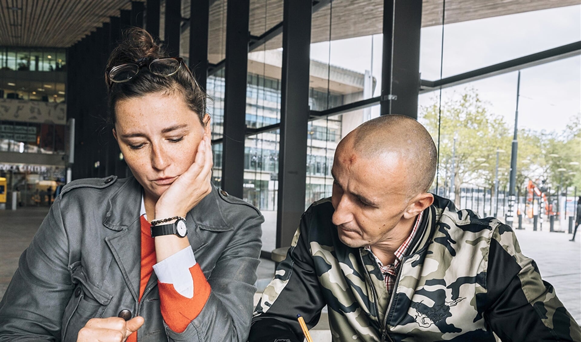 De Poolse dakloze Szymon en maatschappelijk werker Anna Bartmann van de stichting Barka bellen op Rotterdam Centraal met een uitzendbureau.
