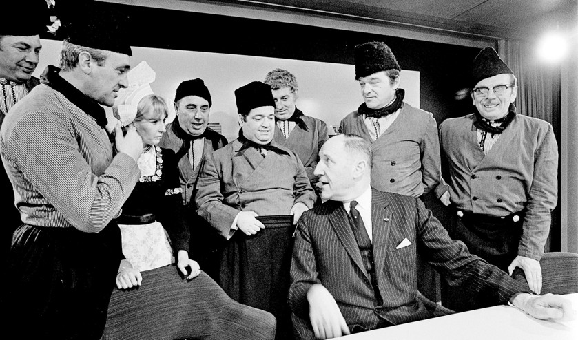 Joseph Luns tijdens een persconferentie in 1969 op luchthaven Schiphol, omringd door Nederlandse artiesten die daar op dat moment ook net waren. (anp)