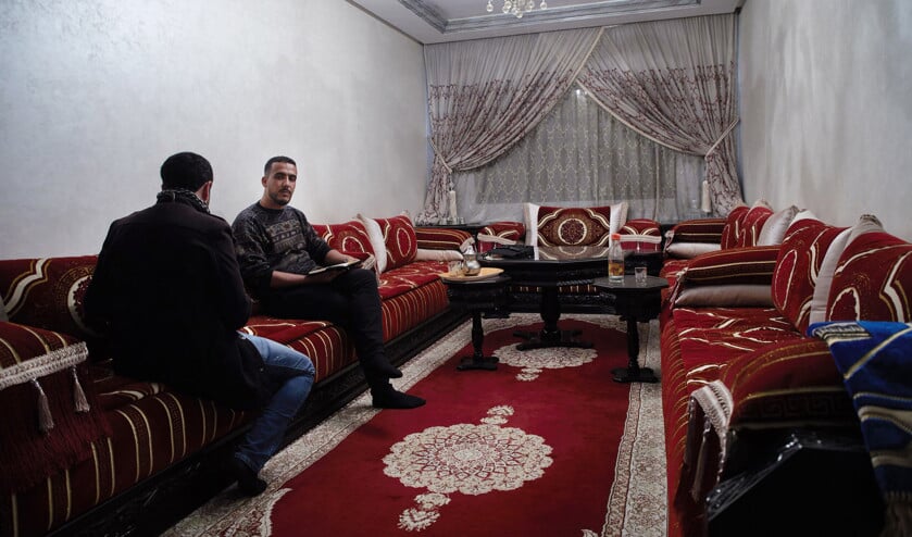 Mehdi Daniel (links) wil niet herkenbaar in beeld in de huiskamer annex ondergrondse kerk in Rabat. (Jaco Klamer)
