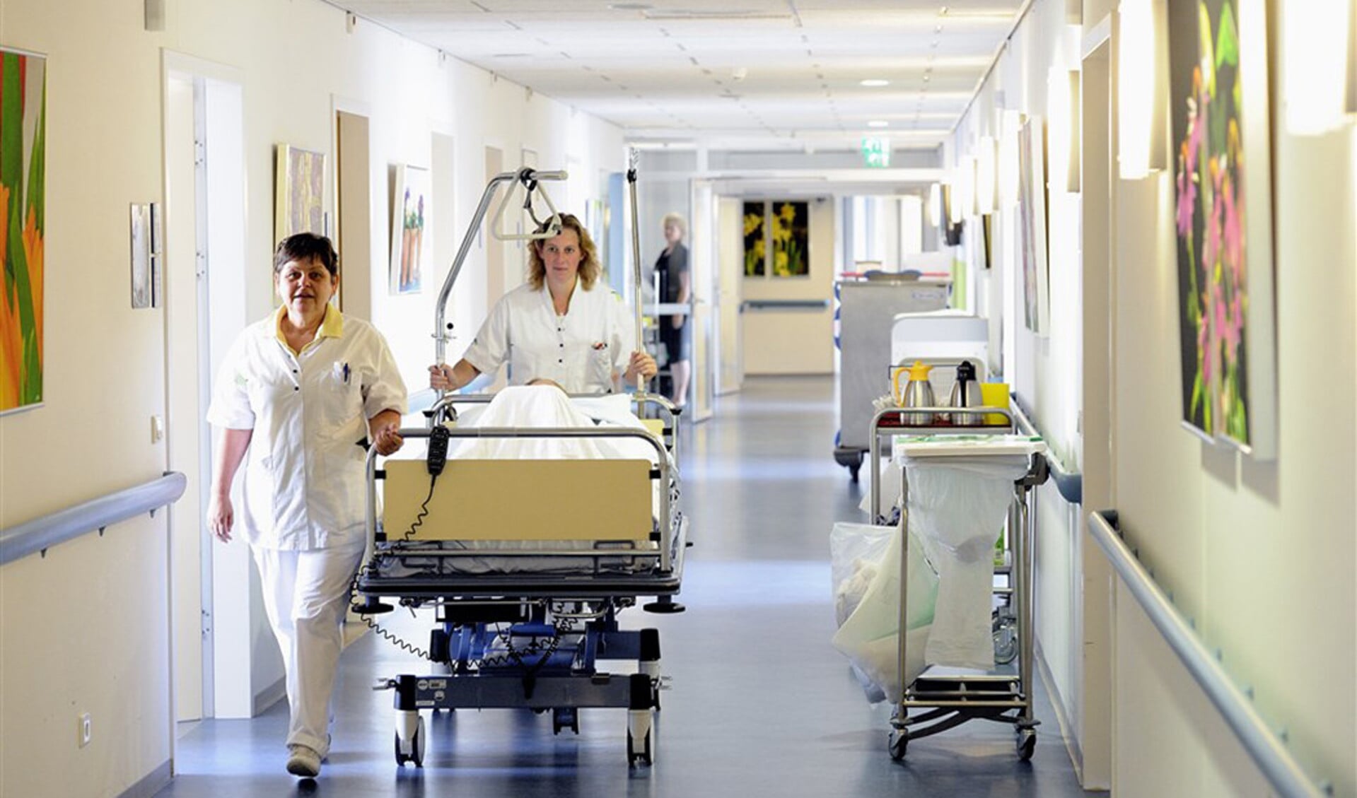 In het Ikazia Ziekenhuis in Rotterdam brengen verpleegkundigen een bedlegerige patiënt terug naar de zaal.
