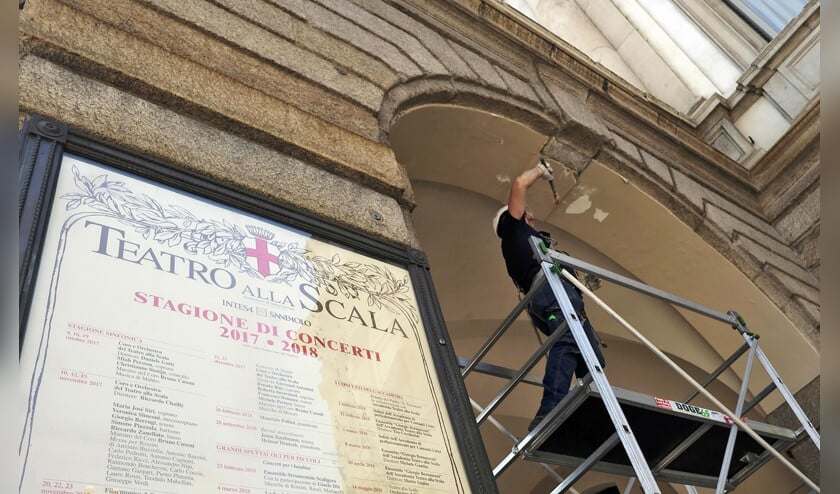 Een man voert controles uit aan een van de bogen van het Teatro alla Scala in Milaan, nadat geconstateerd was dat hier en daar stukken pleisterwerk waren losgeraakt. (epa / Matteo Bazzi)