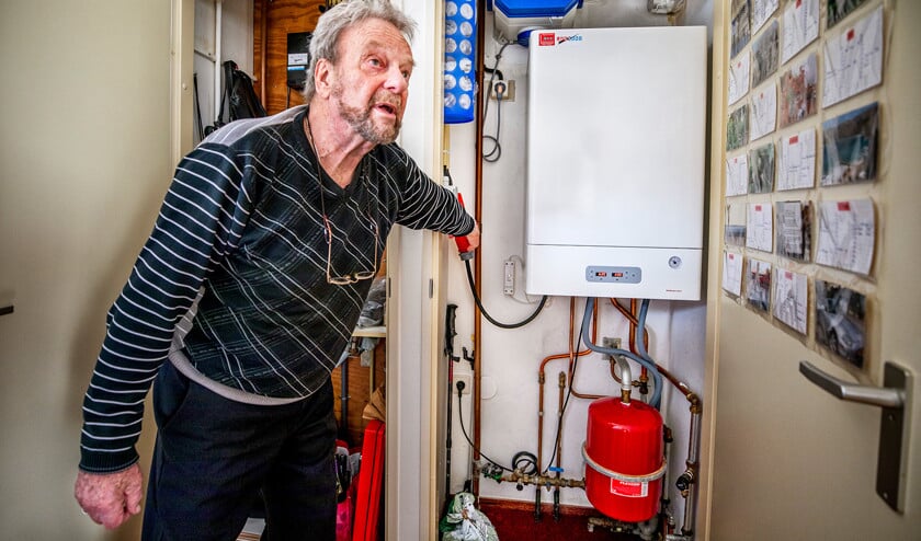 Mar Aalders bij de elektrische verwarmingsketel in zijn appartement in Middelburg. Na drie jaar gebruik heeft hij nog geen nadelen ontdekt.  (Raymond Rutting)