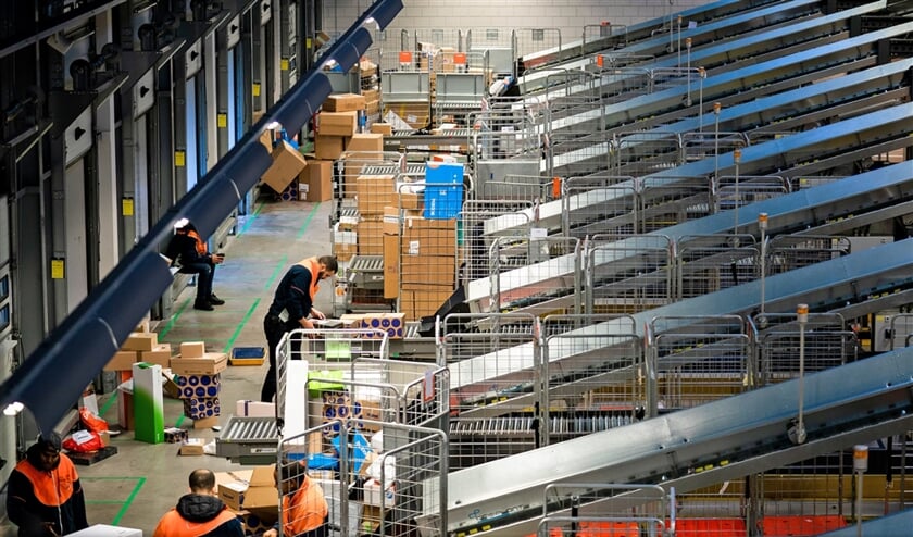 Het PostNL-sorteercentrum in Sassenheim. In deze tijd van het jaar worden er dagelijks 1,5 miljoen pakketten verwerkt. (Freek van den Bergh)