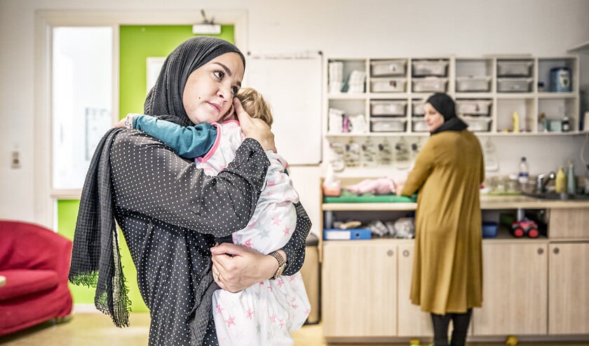 Leidster Hafsa Aoulad troost een kind bij de Kinderster in Amsterdam. ‘Kinderen moeten niet door te veel vreemde gezichten worden omringd.’  (Raymond Rutting)