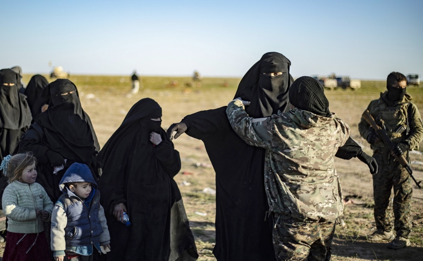Leden van de Koerdische SDF fouilleren Syrische vrouwen en kinderen die wegtrekken uit Baghouz, de laatste enclave van de terreurorganisatie ISIS in Syrië. (afp / Delil Souleiman en anp / Remko de Waal)