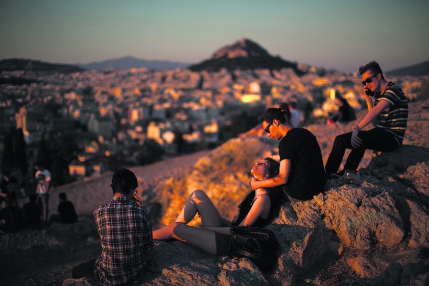 Griekse jongeren kijken uit over Athene. Veel jonge Grieken verlaten het land, anderen proberen vernieuwende bedrijfjes op te zetten. (ap / Emillio Morenatti)